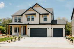 View of front of home with concrete driveway and a garage