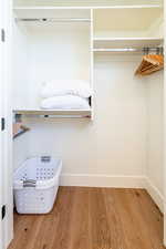 Walk in closet with wood finished floors