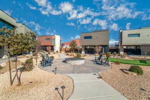 Surrounding community with an outdoor fire pit, a patio, a putting green, and a residential view