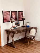 Office area featuring wood finished floors, baseboards, and a textured wall