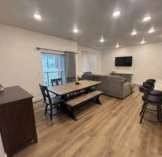 Dining room featuring light wood-style flooring, recessed lighting, baseboards, and a textured ceiling