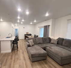 Living room featuring light wood-type flooring, recessed lighting, and baseboards