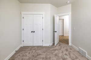 Unfurnished bedroom featuring carpet floors and a closet