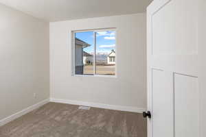 Empty room featuring carpet flooring and baseboards