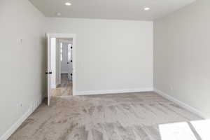 Carpeted empty room with recessed lighting and a smoke detector