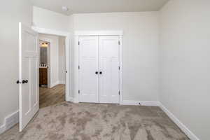 Unfurnished bedroom featuring carpet flooring and a closet