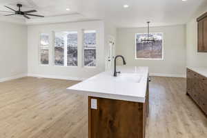 Kitchen featuring light wood-type flooring, light countertops, recessed lighting, decorative light fixtures, and ceiling fan