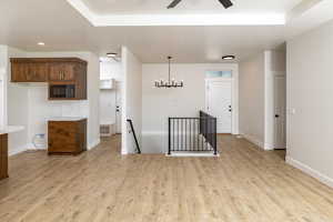 Unfurnished room with light wood-style floors, a ceiling fan, and a chandelier