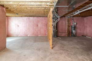 Unfinished basement featuring strapped water heater and heating unit