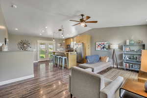 Welcoming entry with open floor plan featuring a ceiling fan, dark laminate finished floors, recessed lighting, and vaulted ceiling
