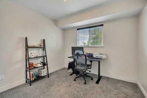 Carpeted home office featuring baseboards