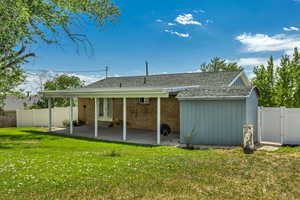 Rear view of property with a shingled roof, a new vinyl fenced backyard, a gate, a patio, and french doors
