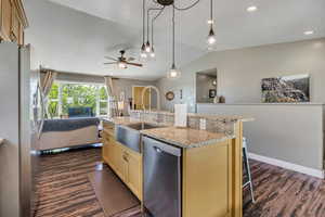 Kitchen featuring appliances with stainless steel finishes, open floor plan, dark wood-style floors, and creamy pale yellow cabinets