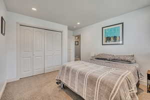 Bedroom with carpet flooring, a closet, and recessed lighting