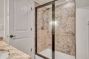 Bathroom featuring a granite surround walk-in shower and vanity