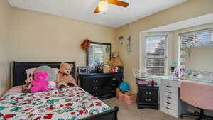 Bedroom with carpet, multiple windows, and ceiling fan
