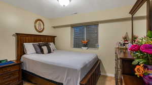 Bedroom featuring baseboards and a textured ceiling