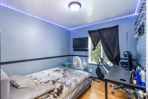 Bedroom with wood finished floors and a desk
