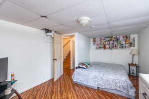 Bedroom featuring a paneled ceiling and baseboards