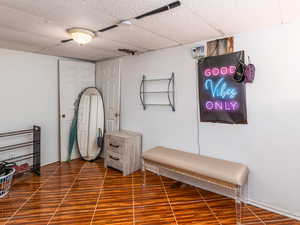 Finished below grade area featuring wood finished floors and a drop ceiling