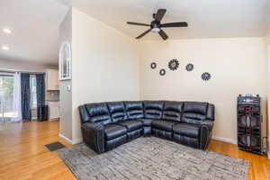 Living room with light wood finished floors, a ceiling fan, and recessed lighting