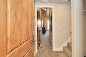 Hall featuring light carpet and baseboards