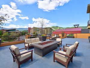 View of private community patio with a mountain view and an outdoor lounging space with a fire pit