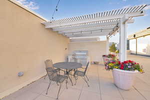 View of patio featuring a pergola, outdoor dining space, and area for grilling