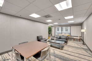 Home office featuring a drop ceiling and carpet