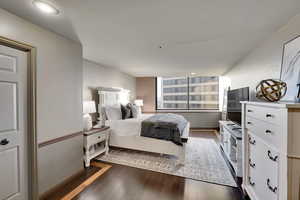Bedroom with dark wood-style flooring