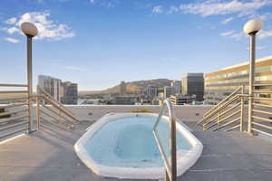 View of swimming pool with a city view, a hot tub, and a mountain view