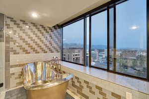 Bathroom with expansive windows, tile walls, tile patterned flooring, a mountain view, and a city view