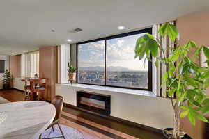 Dining room with a fireplace, wood finished floors, healthy amount of natural light, a mountain view, and recessed lighting
