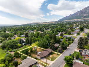 Aerial perspective of suburban area with a mountain backdrop and property parcel outlined