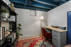 Office with concrete floors and beamed ceiling
