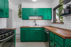 Kitchen with butcher block countertops, range with gas cooktop, and decorative backsplash