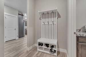 Mudroom featuring light wood-style flooring and baseboards