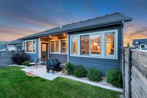 Back of property at dusk with a patio area