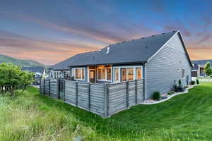 Back of house at dusk featuring a shingled roof, central AC unit, and a mountain view