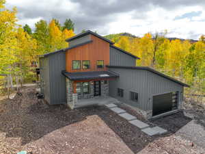 Modern home featuring stone siding, a porch, a metal roof, and a standing seam roof