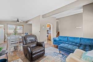 Living area featuring a ceiling fan, light tile patterned flooring, and arched walkways