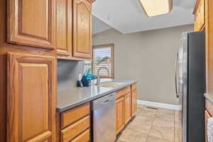 Kitchen featuring stainless steel appliances, light tile patterned floors, and light countertops