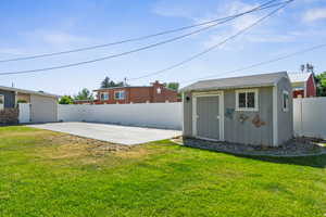 Fenced backyard featuring a patio area and a storage shed