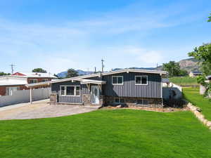 View of front of property with board and batten siding, a mountain view, stone siding, and a carport