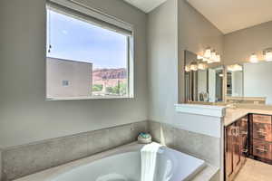 Bathroom with vanity, a bath, a mountain view, and tile patterned floors