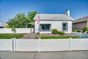 Bungalow-style home featuring a fenced front yard and a chimney