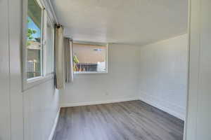 Unfurnished room featuring wood finished floors and an ornate ceiling