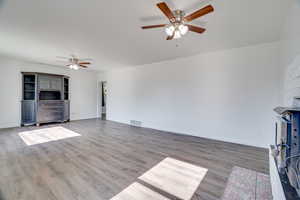 Unfurnished living room with a ceiling fan and wood finished floors
