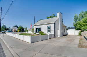Bungalow-style house featuring a gate, a chimney, and concrete driveway