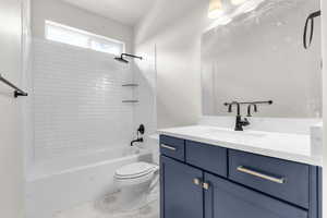 Bathroom featuring bathtub / shower combination, vanity, and light tile patterned floors